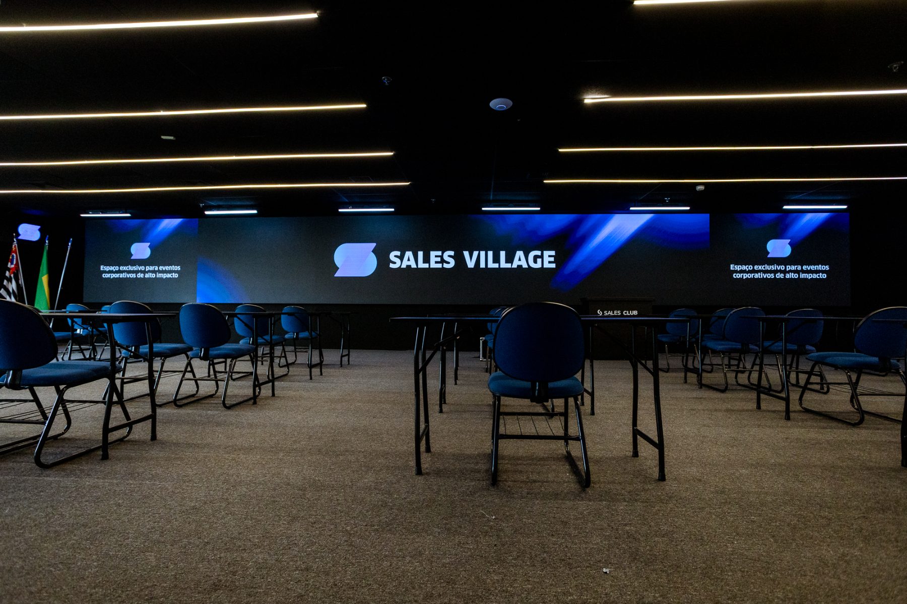 Auditório do Sales Village com painel de LED gigante exibindo a marca Sales Village